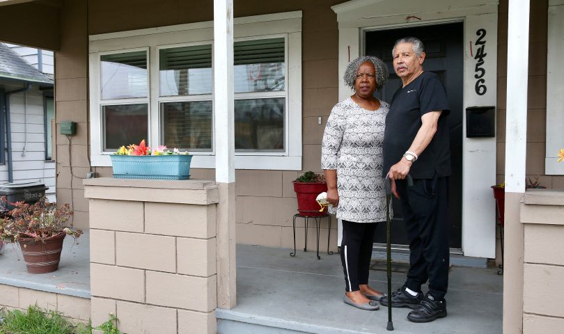 Image of older couple standing on their porch.
