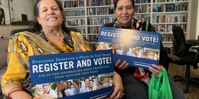 Residents holding "register and vote" signs