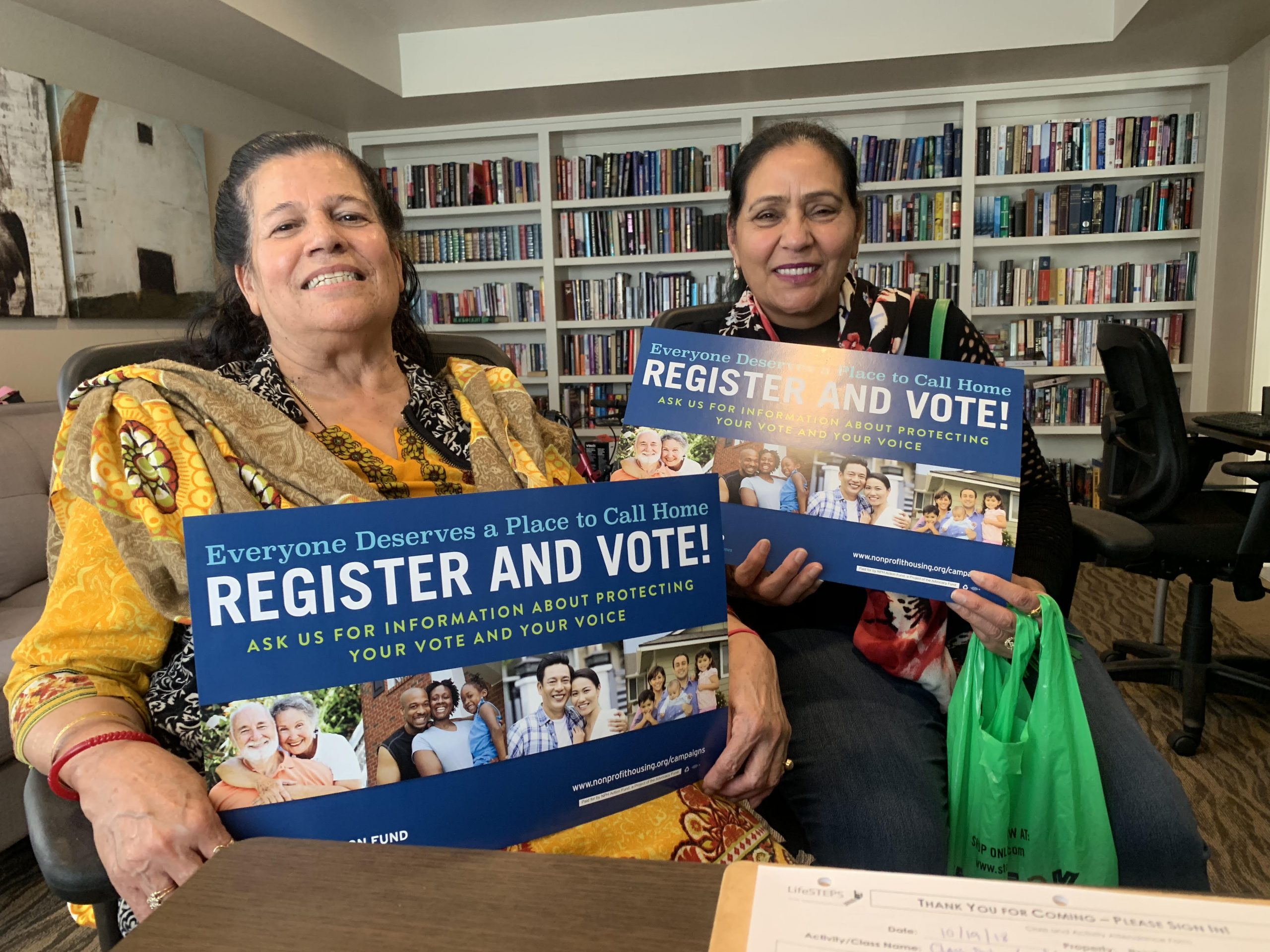 Residents holding "register and vote" signs