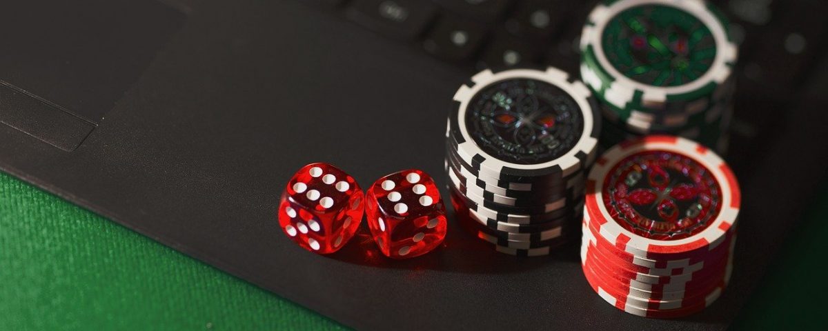 Poker chips and dice on a laptop
