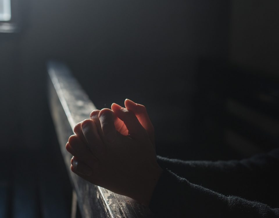 Hands being illuminated by light on a pew