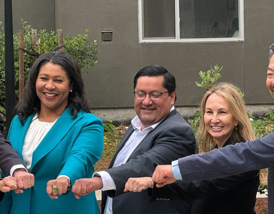 Mayors of major bay area cities and Amie putting hands together for photo