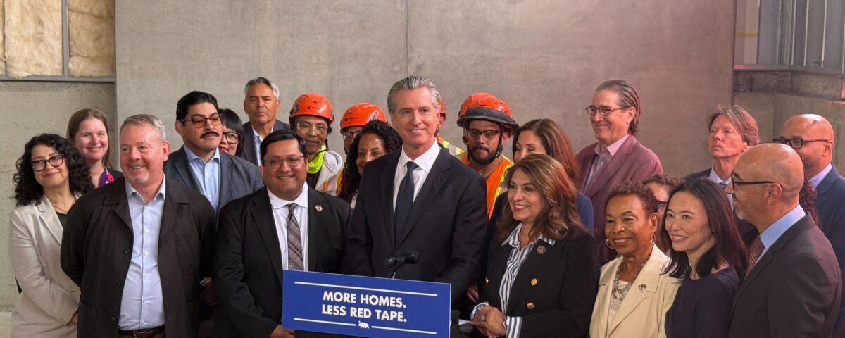 Governor Newsom at podium surrounded by other elected officials and advocates